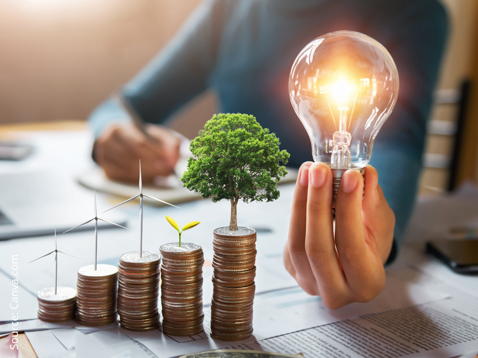 coins arranged in columns and a hand holding a lit light bulb